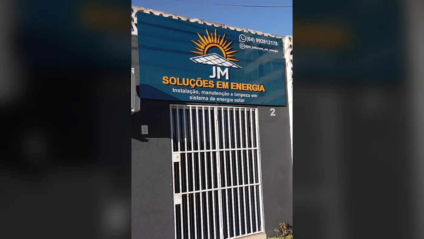 Fachada inteira da JM Soluções em Energia, com a placa, a logo, o WhatsApp e a descrição Instalação, manutenção e limpeza em sistema de energia solar